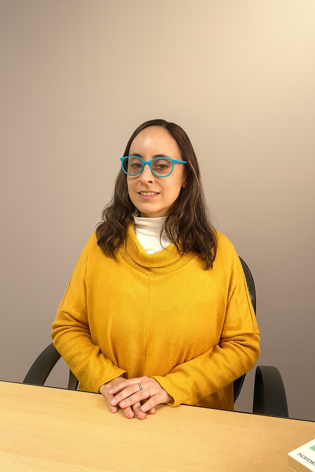 Natalia Forti - Psicóloga profesional con anteojos azules en su consultorio
